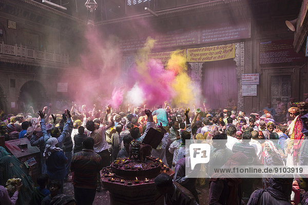 Devotees celebrating and throwing coloured powder  Holi festival  Banke Bihari Temple  Vrindavan  Uttar Pradesh  India