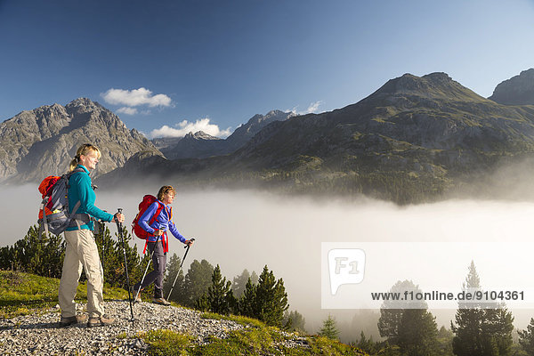 Zwei Frauen beim Wandern  tiefhängende Wolken am Ofenpass  Schweizerischer Nationalpark  Graubünden  Schweiz