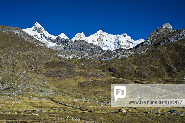 Tent camp  at the back the snow-capped Mt Trapecio and Mt Nevados Jurau  Cordillera Huayhuash mountain range  Northern Peru  Peru