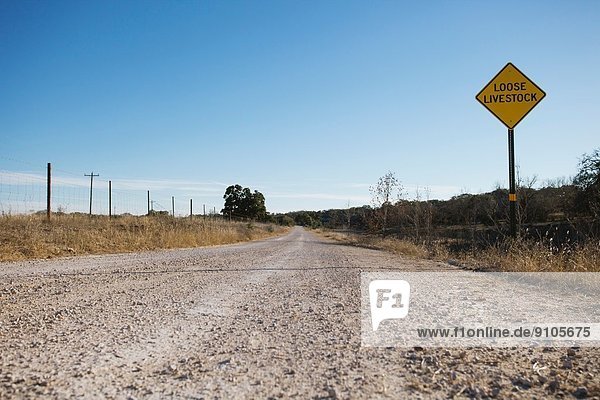 Empty dirt road with sign  Texas  USA