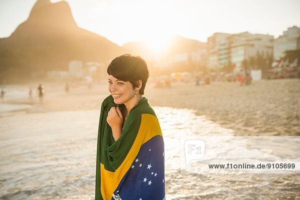 Junge Frau in brasilianischer Flagge Strand von Ipanema Rio Brasilien