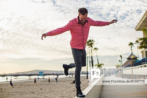 Junger Mann beim Balancieren an der Wand  Long Beach  Kalifornien  USA