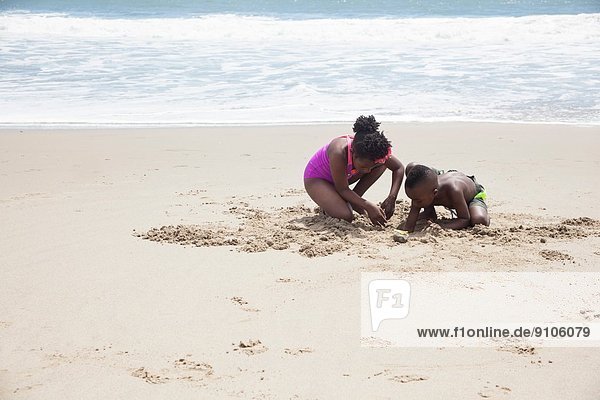 Children digging in sand on beach