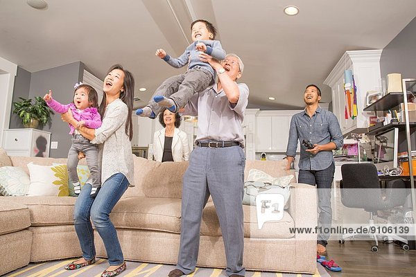 Drei Generationen Familie mit Spaß im Wohnzimmer