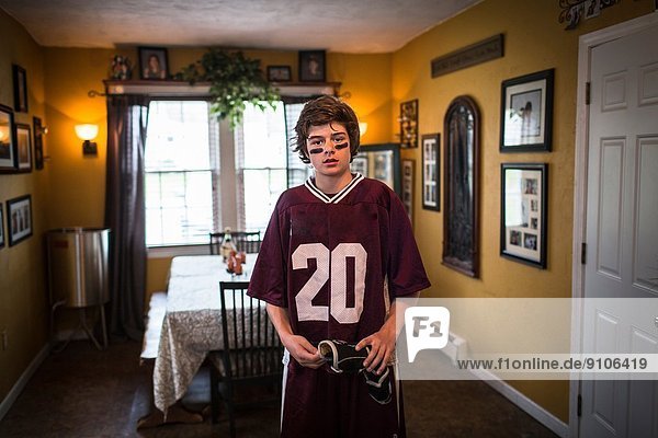 Teenager-Junge in Lacrosse-Uniform  im Esszimmer stehend
