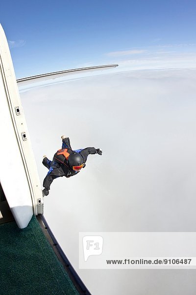 Mittlerer Erwachsener Mann in der Luft  der sich darauf vorbereitet  im Wingsuit zu fliegen.
