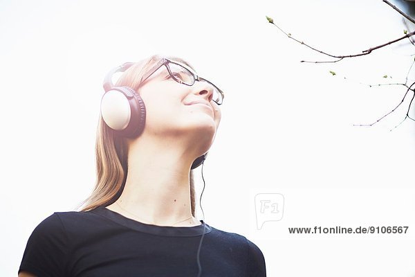 Junge Frau mit Kopfhörer beim Musikhören