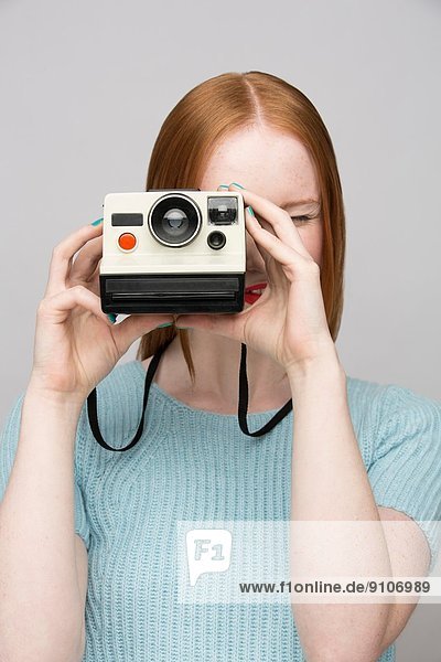 Junge Frau mit Polaroidkamera