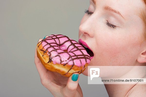 Junge Frau beißt Donut