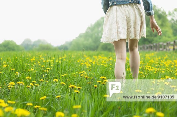 Taille unten Rückansicht der jungen Frau beim Spaziergang auf dem Feld