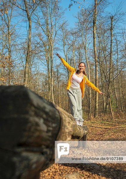 Junge Frau beim Balancieren auf dem Waldangriffsplatz