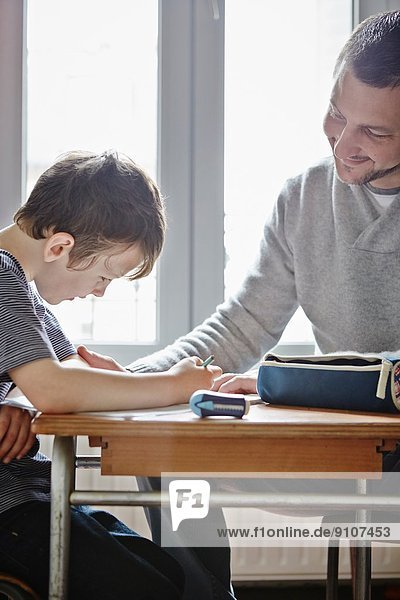 Vater hilft dem Sohn bei den Hausaufgaben