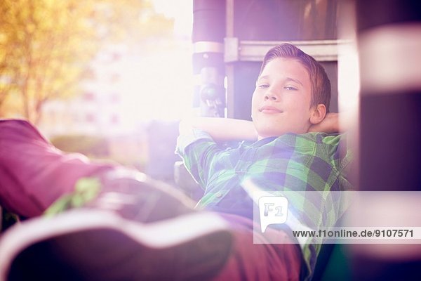 Portrait of boy relaxing with hands behind head