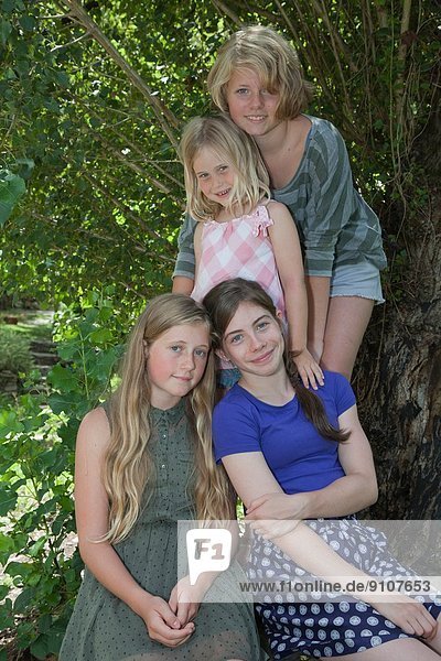 Vier Mädchen neben dem Baum