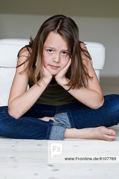 Porträt eines unglücklichen zwölfjährigen Mädchens mit Kopf in den Händen