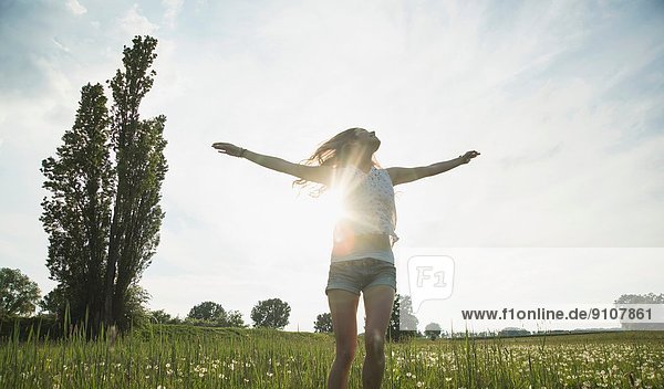 Young woman jumping in field