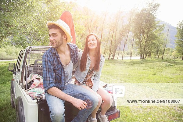 Junges Paar sitzend auf dem Rücken eines Pick-up Trucks  Piemonte  Italien