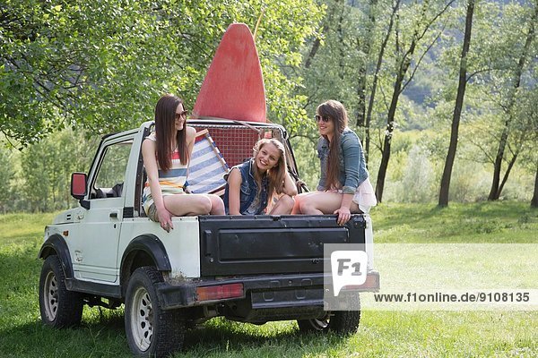 Freunde sitzen auf dem Rücksitz eines Geländewagens.