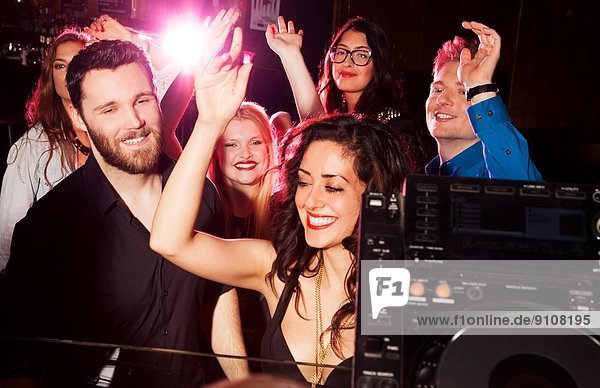 Gruppe junger Männer und Frauen  die in einem Nachtclub tanzen.