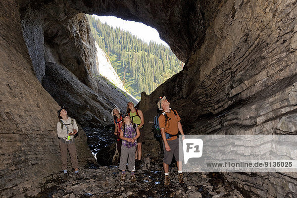 Two young families explore cave on Mountain Lakes Trail near Fernie  BC  Canada.