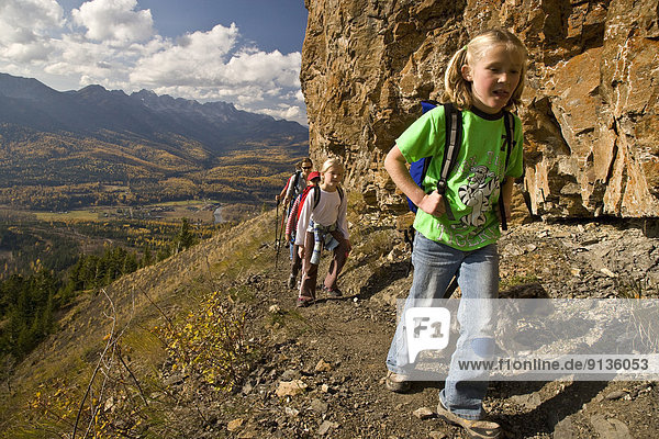 Young family hiking on Castle Mountain Trail in autumn  Fernie  BC  Canada.