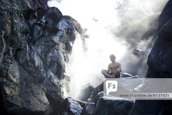 A visitor enjoys the steaming and natural mineral hot springs at Hot Springs Cove in Maquinna Provincial Park on Vancouver Island near Tofino  British Columbia  BC  Canada.