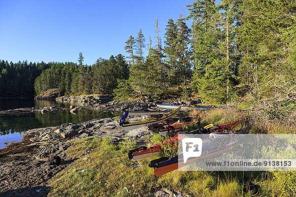 Kayaks rest above the high tide mark on Octupus Island Provincial Marine Park  British Columbia  Canada