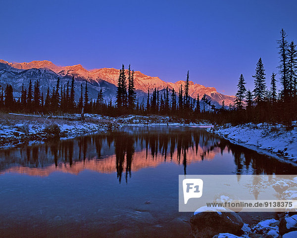 An alpenglow sunset on the Miette Mountain Range in Jasper National Park Alberta Canada.
