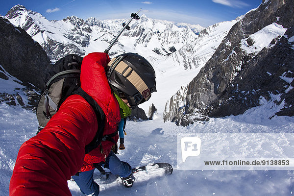 A male splitboarder captures a self portait pov while descending a steep couloir on Mt French  Peter Lougheed Provincial Park  Kananaskis  AB