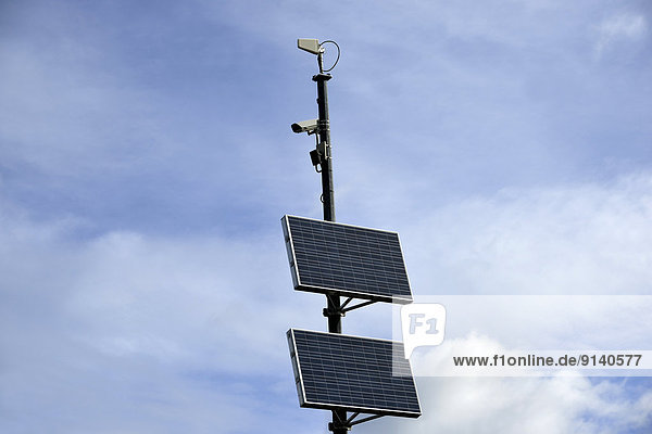 A remote highway camera with solar pannel operating system against a sky background.