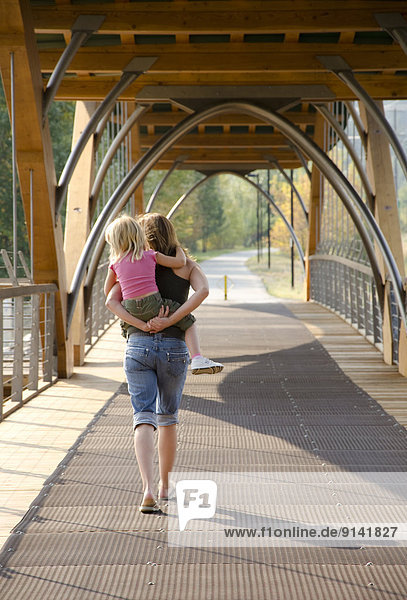 Mother and young daughter enjoy a leisurely walk on the Bridge of Dreams in Princeton in the Similkameen region of British Columbia  Canada