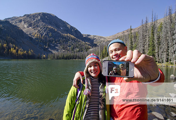 Young couple stop for a self-portrait while hiking near Cathedral Lakes Lodge in the Similkameen region of British Columbia  Canada