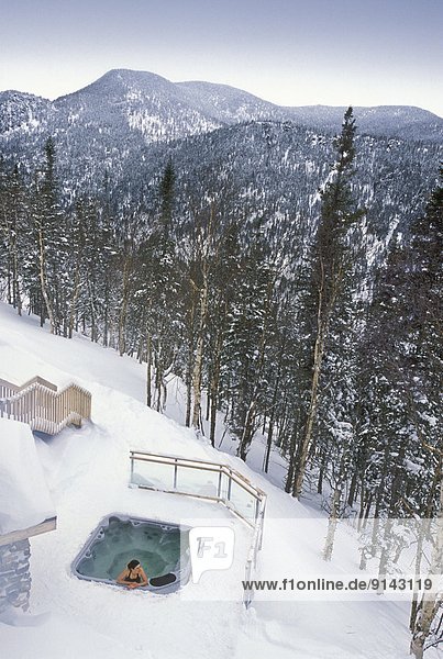 woman in outdoor hot tub in winter  ChicChocs Mountains  Quebec  Canada