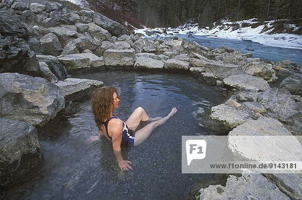 Woman in natural hotspring in winter  Lussier Hotsprings  British Columbia  Canada
