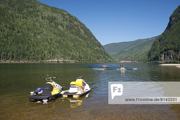 Personal watercraft on Three Valley Lake  Three Valley Lake Chateau resort in the background  Hwy #1  west of Revelstoke  British Columbia  Canada