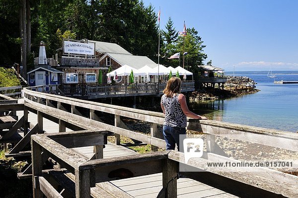 A woman enjoying the views on the boardwalk in Lund  BC.