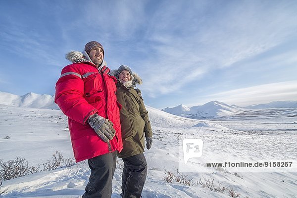 Happy couple standing on a hill along the DempsterHighway  Yukon.