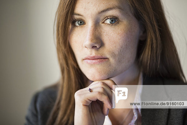 Porträt einer selbstbewussten Geschäftsfrau mit Hand am Kinn