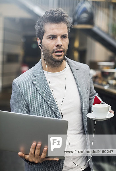 Mittlerer Erwachsener Mann mit Laptop und Kaffee im Cafe