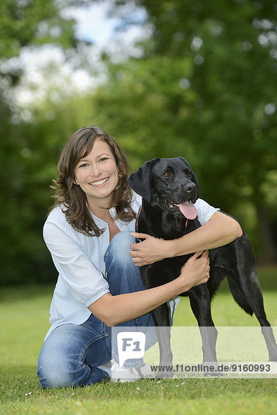 Woman with a black labrador on a meadow  Bavaria  Germany  Europe
