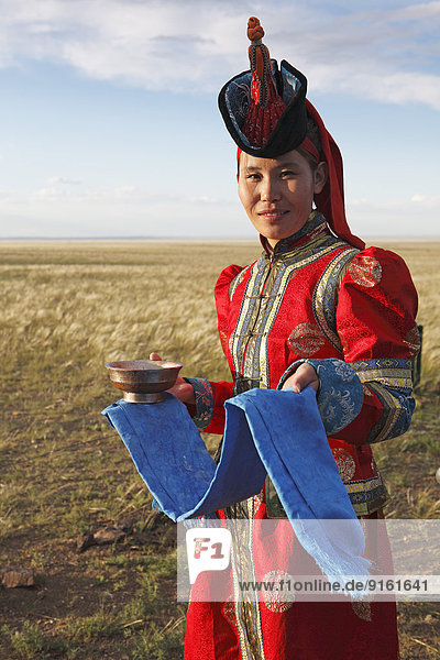 Frau in Tracht mit traditionellen Begrüßungsutensilien blaues Tuch und Schale Milch Wüste Gobi Südwüste Ömnö-Gobi-Aimag Mongolei