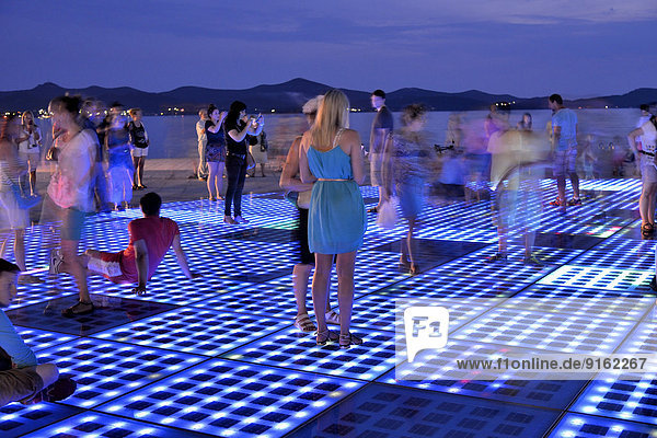 Menschen auf dem Sonnenmonument  Pozdrav Suncu  Architekt Nikole Ba?i?a  in der Abenddämmerung  Zadar  Dalmatien  Kroatien