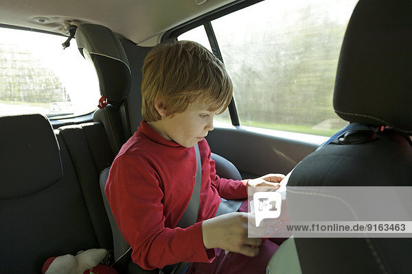 Junge liest im Auto