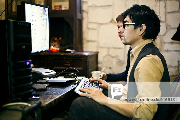 Men using computer at desk