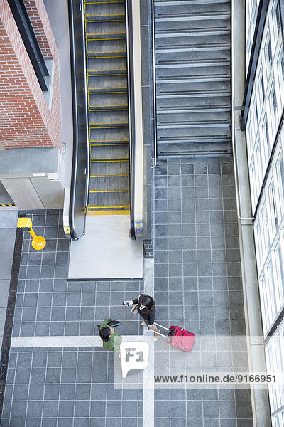 Businesswomen talking near stairs and escalator
