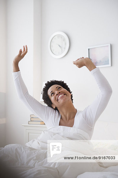 Happy Black woman awaking in bed