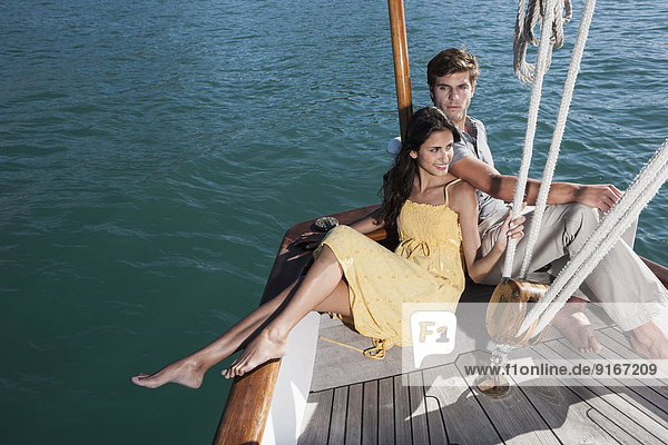 Caucasian couple relaxing on sailboat
