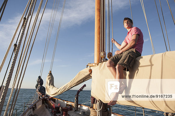 Caucasian man relaxing on sailboat
