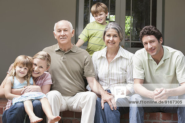 Caucasian multi-generation family smiling on porch