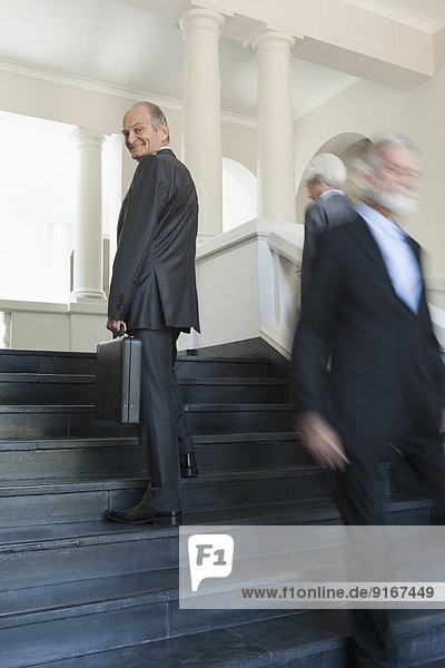 Senior Caucasian businessmen climbing office steps